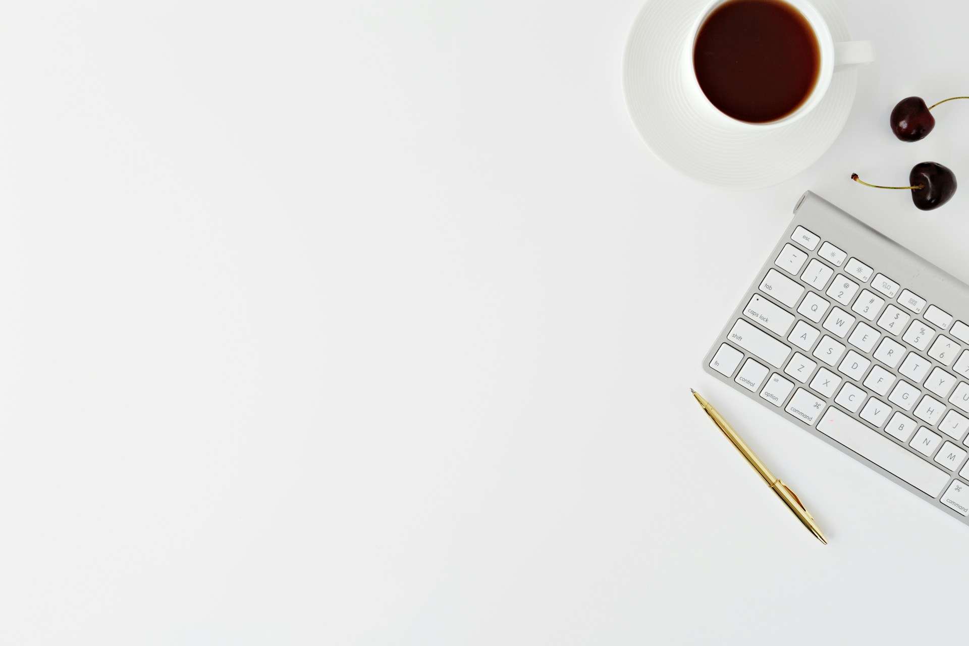 Clavier et café vus du dessus sur un bureau blanc